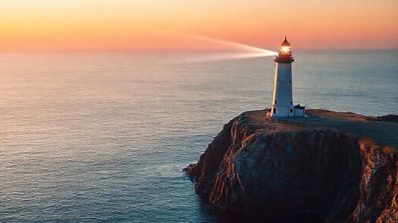 A photorealistic image of a calm, clear digital ocean at sunrise, with a lighthouse standing tall and strong on a solid, well-maintained cliff, emitting a powerful beam of light, symbolizing guidance, stability, and continuous protection for digital assets. Cinematic lighting, sharp focus on the lighthouse, depth of field blurring the distant horizon, 8K hyper-detailed, professional photography, shot on a high-end DSLR.