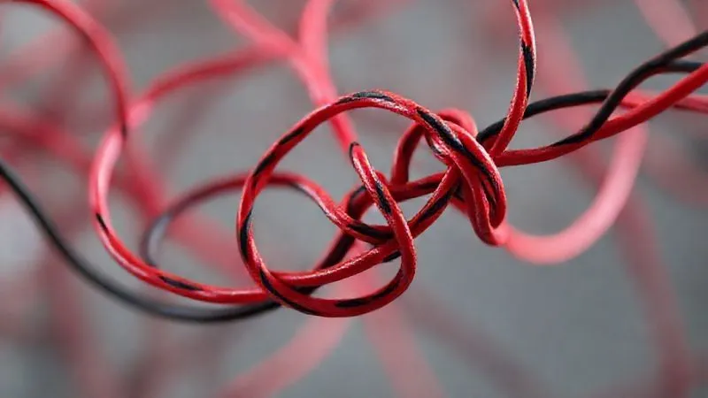 A photorealistic image of a complex, tangled knot of red and black wires, symbolizing common pitfalls and errors in digital strategy. A single, clear path emerges from the knot, representing the solution. Cinematic lighting, sharp focus on the knot, depth of field blurring the background. 8K hyper-detailed, shot on a high-end DSLR.